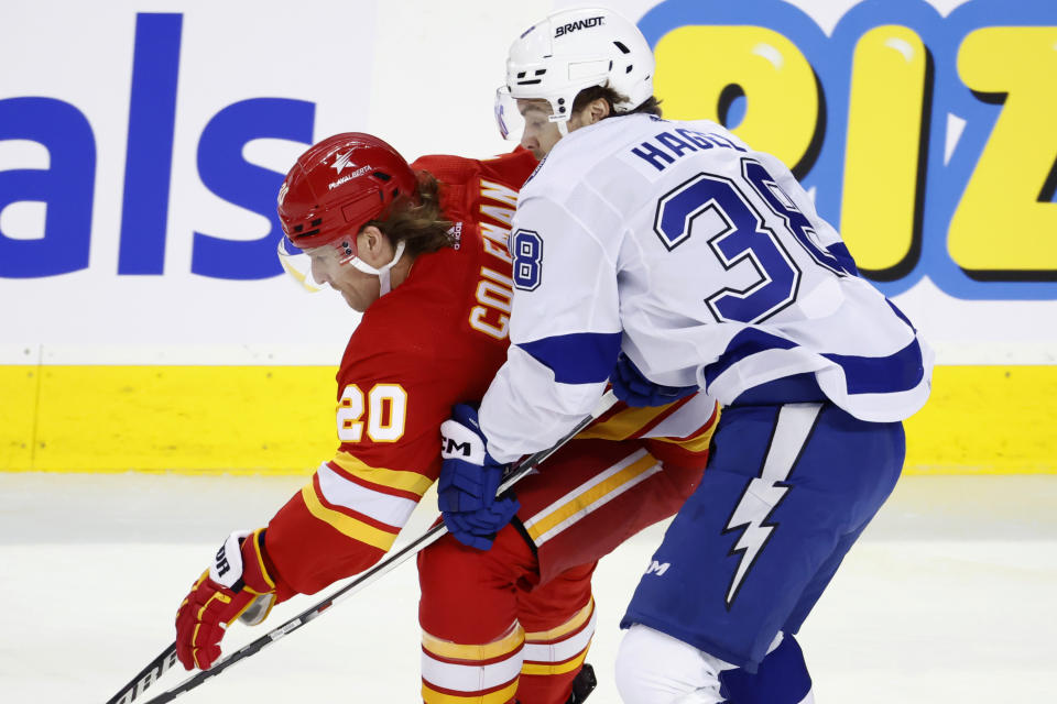 Tampa Bay Lightning left wing Brandon Hagel (38) defends against Calgary Flames center Blake Coleman (20) during the first period of an NHL hockey game Saturday, Dec. 16, 2023, in Calgary, Alberta. (Larry MacDougal/The Canadian Press via AP)