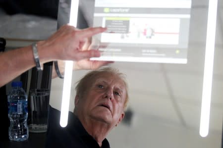 Larry Sloven shows a touch mirror that can be used as a tablet, at a factory in Bangkok