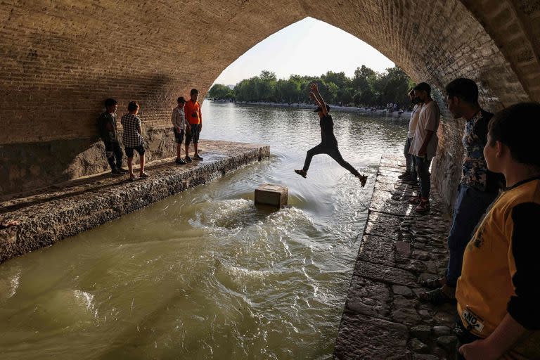 Un niño salta sobre uno de los arcos del puente "Si-o-Se Pol", a lo largo del río Zayandeh Rood en Irán.