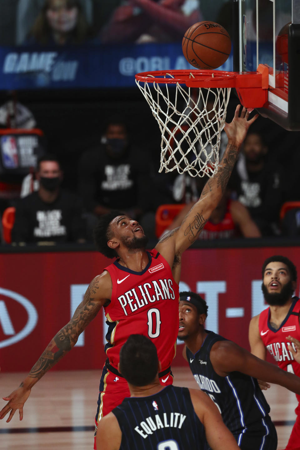 New Orleans Pelicans guard Nickeil Alexander-Walker (0) shoots a layup over Orlando Magic center Nikola Vucevic, foreground, during the first half of an NBA basketball game Thursday, Aug. 13, 2020, in Lake Buena Vista, Fla. (Kim Klement/Pool Photo via AP)