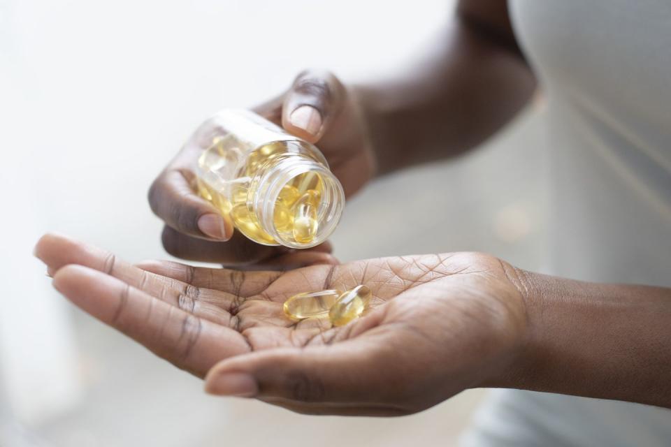 woman pouring capsules into her hand