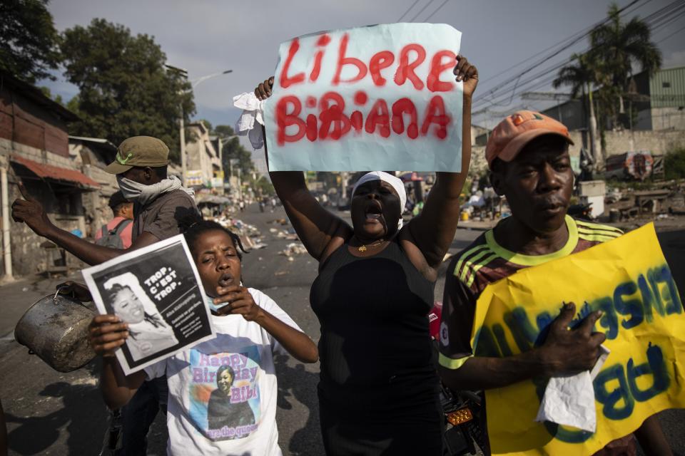 People chant anti-government slogans during a protest organized by friends and relatives of Biana Velizaire, who was kidnapped and held for several days by gang members, in Port-au-Prince, Haiti, Monday, Sept. 27, 2021. Haitian police on Monday launched a special operation in response to the recent surge of kidnappings conducted by gangs. (AP Photo/Rodrigo Abd)