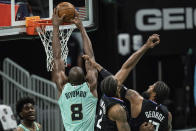 Charlotte Hornets center Bismack Biyombo (8) dunks the ball while guarded by Los Angeles Clippers forward Kawhi Leonard (2) and guard Paul George (13) during the first half of an NBA basketball game in Charlotte, N.C., Thursday, May 13, 2021. (AP Photo/Jacob Kupferman)