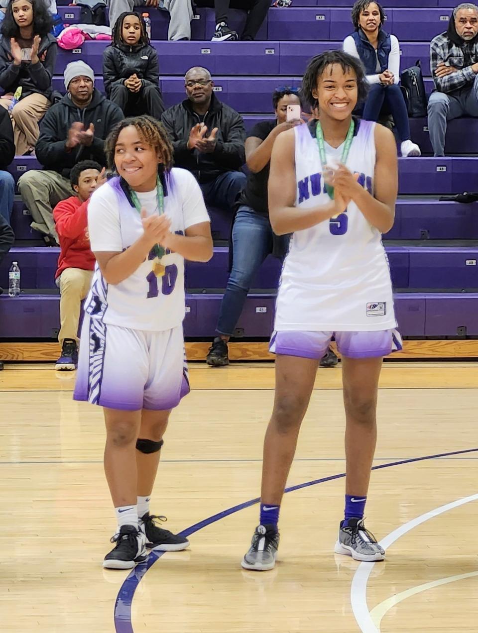 Africentric's Jayona Overby, left, and Samairah Thompson smile as the Nubians receive their Division III district championship medals Thursday at Capital.