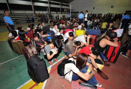 Hundreds of Taiwanese and mainland Chinese rounded up by Philippine police on suspicion of being involved in a major telephone scam wait to be processed by authorities at a police station in Canlubang, south of Manila, on August 23. The gang would pose as police and government prosecutors, telling their victims they had legal problems and would have to transfer money to a certain account