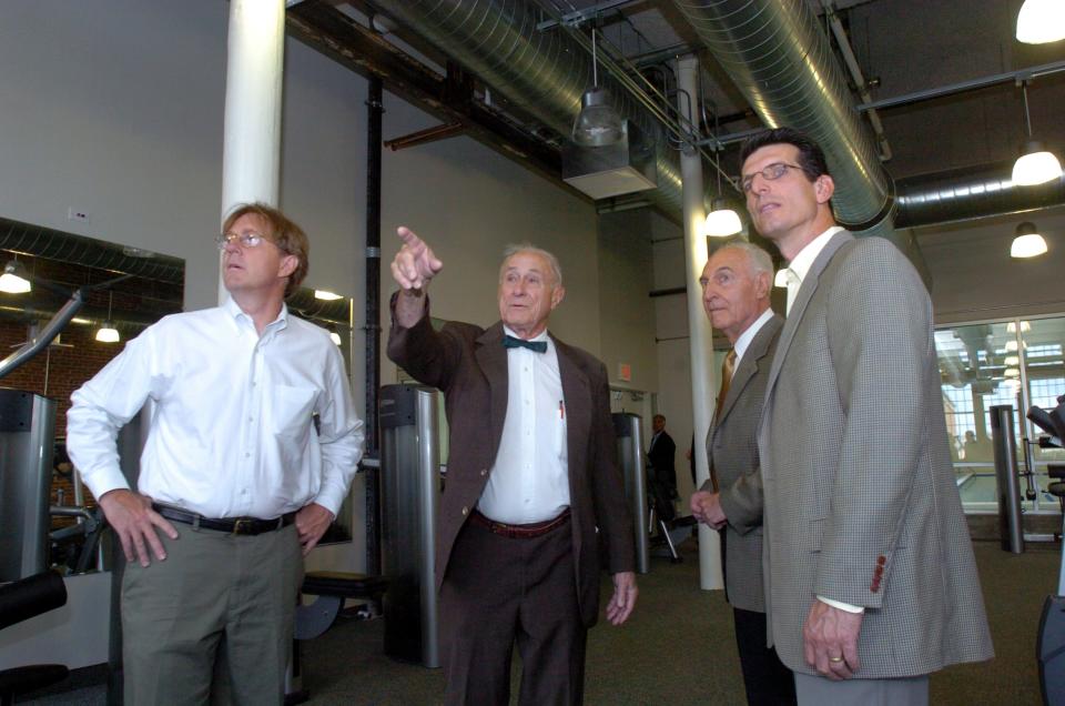 During a tour of the The Promenade apartment complex in Providence in 2005, Henry Dexter Sharpe Jr., second from left, points out a feature of the old mill to his son Douglas, left, and two of the project's owners, Tony Guerra, second from right, and his son Tom, far right. Henry Sharpe sold the building, the former Brown & Sharpe mill, to the Guerras and Tony Thomas.