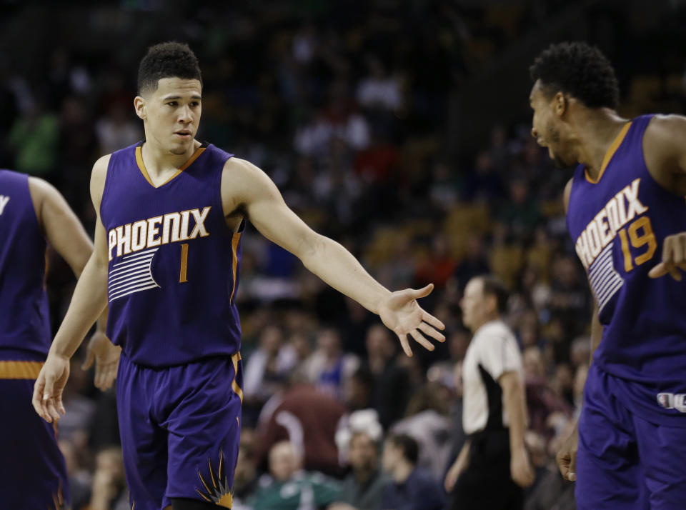 Phoenix Suns guard Devin Booker (1) is congratulated by guard Leandro Barbosa (19) in the fourth quarter of an NBA basketball game against the Boston Celtics, Friday, March 24, 2017, in Boston. Booker scored 70 points, but the Celtics won 130-120. Booker is just the sixth player in NBA history to score 70 or more points in a game. (AP Photo/Elise Amendola)