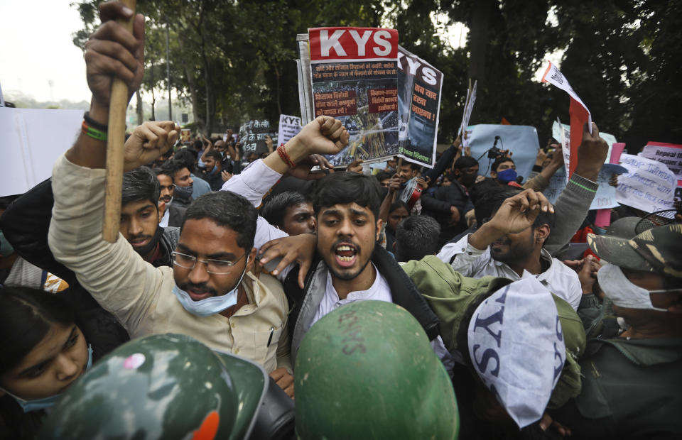 Security officers, in the foreground, push back people shouting slogans during a demonstration held in support to farmers who have been on a months-long protest, in New Delhi, India, on February 3, 2021.  / Credit: Manish Swarup/AP