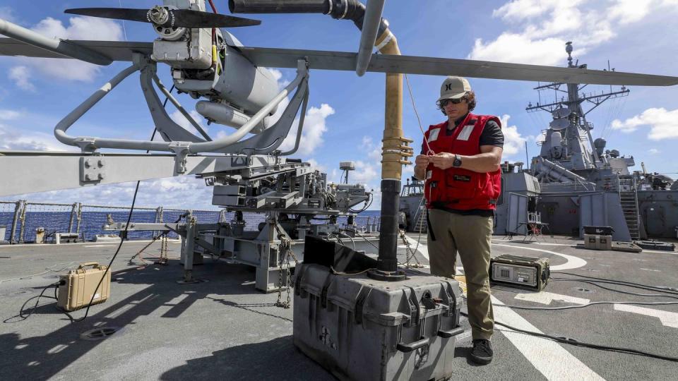 Ben Seay prepares an Aerosonde unmanned aerial vehicle for launch on the flight deck aboard Arleigh Burke-class guided-missile destroyer USS Higgins (DDG 76) while conducting routine operations in the Philippine Sea on Sept. 2, 2022.  (MC1 Donavan Patubo/U.S. Navy)