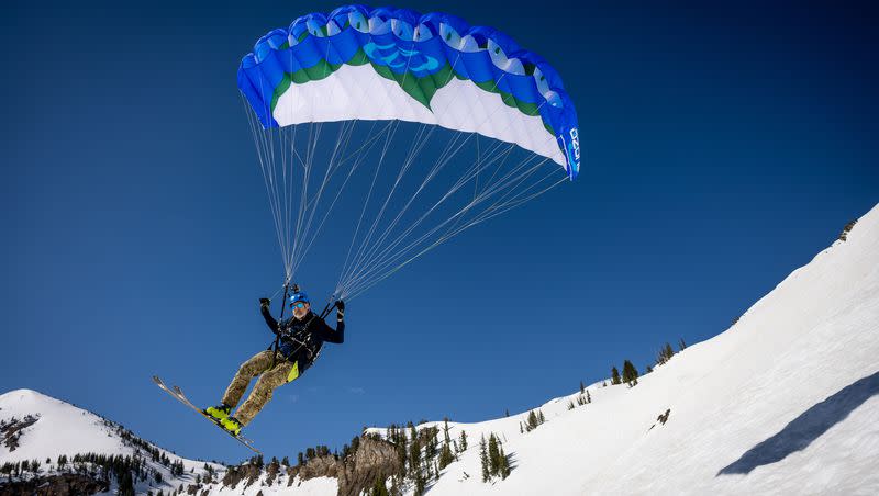 Dan Schilling, a special operations veteran and bestselling author, speed rides down the slopes at Alta Ski Area, which has closed for the season, on Wednesday, May 17, 2023. Speed riding is a sport in which one uses a small paragliding wing to quickly descend snow-covered mountains on skis.