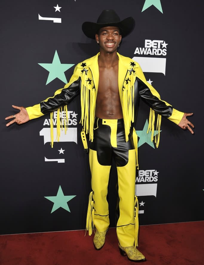 Lil Nas X wearing a bright yellow and black look complete with python cowboy boots at the BET Awards. - Credit: Shutterstock