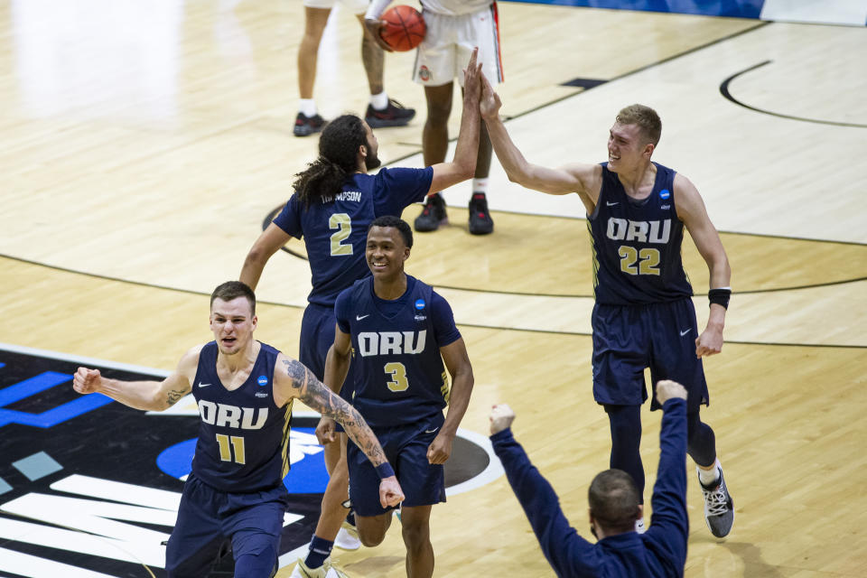 Oral Roberts players celebrate after beating Ohio State in a first-round game in the NCAA men's college basketball tournament, Friday, March 19, 2021, at Mackey Arena in West Lafayette, Ind. (AP Photo/Robert Franklin)