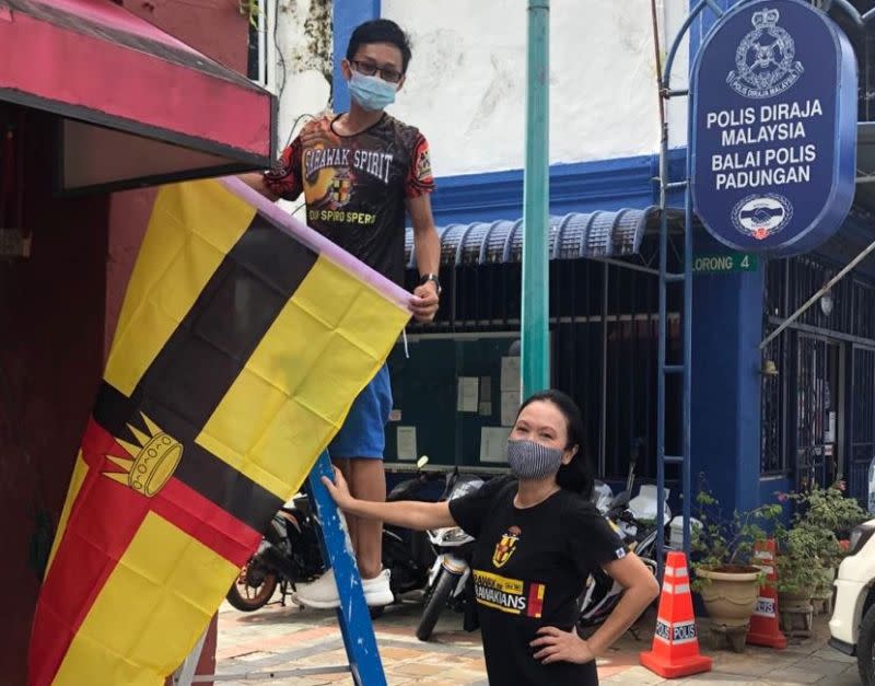 Aspirasi president Lina Soo and party member Lucas Chin installing Sarawak’s historical flag along Padungan Street September 3, 2020. — Picture courtesy of Lina Soo