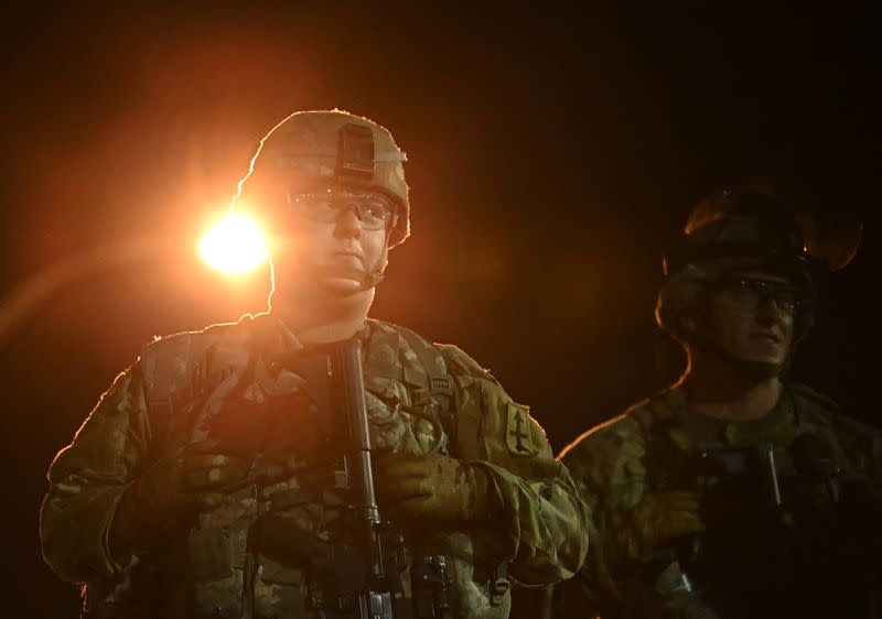 Members of the Wisconsin National Guard keep watch at their post behind the Kenosha Police Department building following the police shooting of Jacob Blake, a Black man, in Kenosha