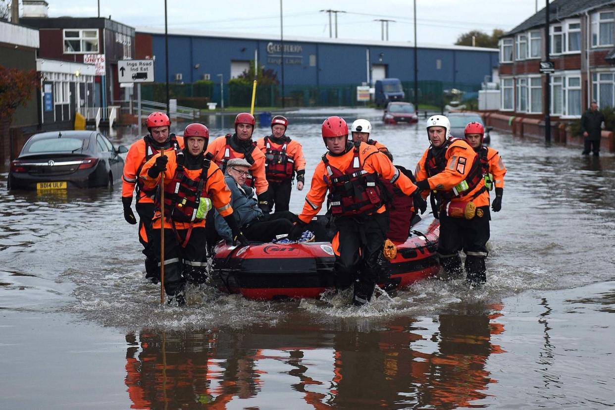 Members of the Fire and Rescue service evacuate an elderly resident to dry land in Doncaster: AFP via Getty Images