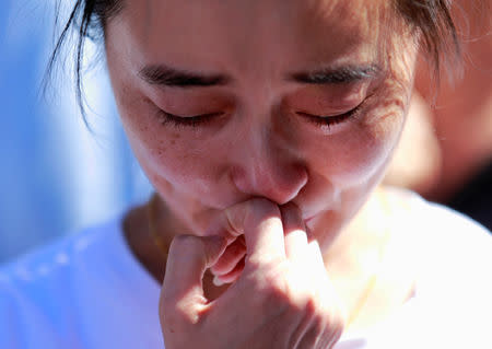 FILE PHOTO: A family member of a passenger onboard the missing Malaysia Airlines Flight MH370 cries as she gathers with others to pray at Yonghegong Lama Temple in Beijing September 8, 2014, on the six-month anniversary of the disappearance of the plane. REUTERS/Kim Kyung-Hoon/File Photo