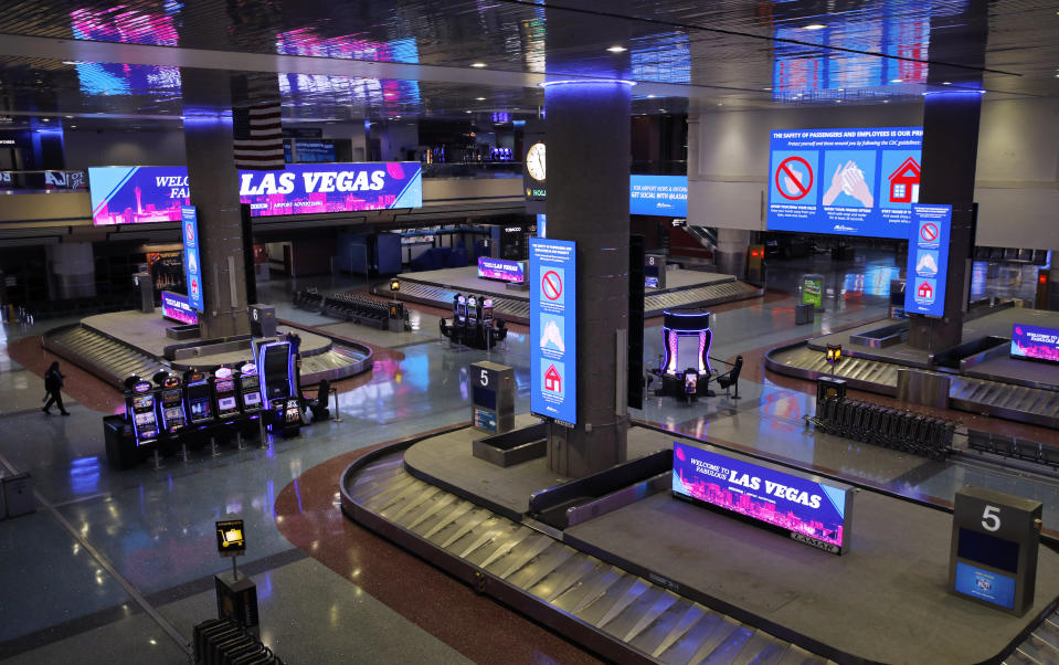 In this April 21, 2020, photo, electric signs that usually advertise casinos and other entertainment now give tips on preventing the spread of the coronavirus at McCarran International airport in Las Vegas. Nevada's governor shuttered the glitzy casinos and nightlife attractions of Las Vegas in mid-March, leaving much of the famous gambling mecca empty. (AP Photo/John Locher)