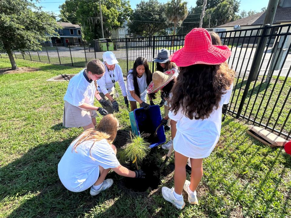 A group of seven students at St. Peter Catholic School in DeLand got the honors of planting a tiny seedling grown from a seed that's been to outer space. The girls are all in the school's garden club. Also pictured in the white ball cap is Carmen Abell, the school's Spanish teacher and garden club sponsor.