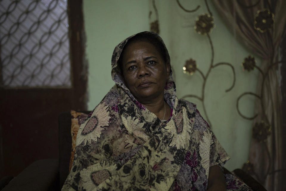 In this Thursday, April 18, 2019 photo, Amal al-Zein, an activist who was detained under former Sudanese President Omar al-Bashir, poses for a photo at her home in Khartoum, Sudan. Former Sudanese President Omar al-Bashir, driven from power in April 2019, and now languishing in a prison where his opponents were once jailed and tortured, is more vulnerable than ever to a decade-old international arrest warrant for war crimes committed in Darfur. But the military, which forced him from power after four months of mass protests, has said it will not extradite him to the International Criminal Court at the Hague, and even many opponents including al-Zein have said they prefer he be tried in Sudan. (AP Photos/Salih Basheer)