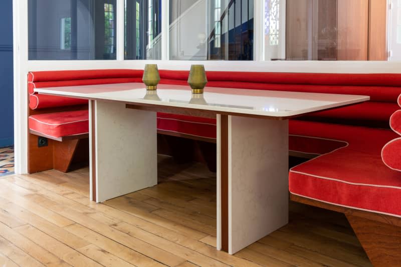 Red banquette and dining table in newly renovated dining room.