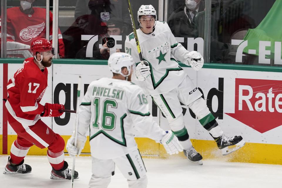 Detroit Red Wings defenseman Filip Hronek (17) skates past as Dallas Stars center Joe Pavelski (16) and left wing Jason Robertson (21) celebrate a goal scored by Robertson in the first period of an NHL hockey game in Dallas, Tuesday, April 20, 2021. (AP Photo/Tony Gutierrez)