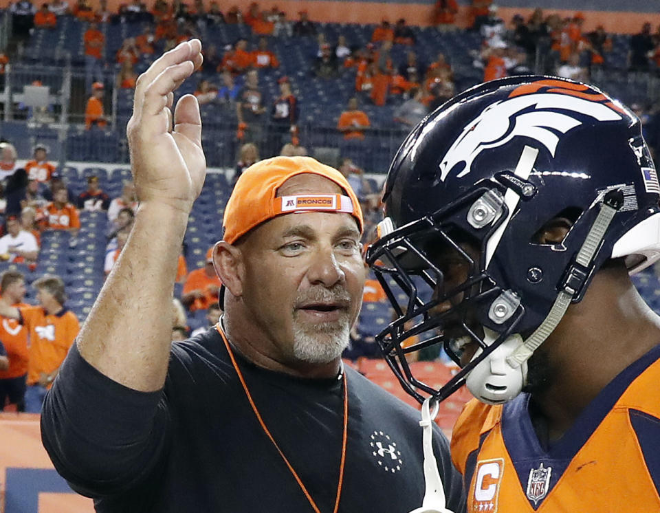 FILE - In this Sept. 11, 2017, file photo, professional wrestler Bill Goldberg, left, greets Denver Broncos outside linebacker Von Miller prior to an NFL football game against the Los Angeles Chargers in Denver. Bill Goldberg punched through the drywall in his garage one day this week -- not as some sort of masochistic training for his next WWE match -- but for repairs on property damage suffered as a result of the deadly Texas storms. The WWE Hall of Famer spent about 12 hours Wednesday, Feb. 24, 2021 replacing pumps in the wells on the ranch he owns just outside San Antonio, and then it was off to work on a garage and pool house that had been flooded. (AP Photo/Jack Dempsey, File)