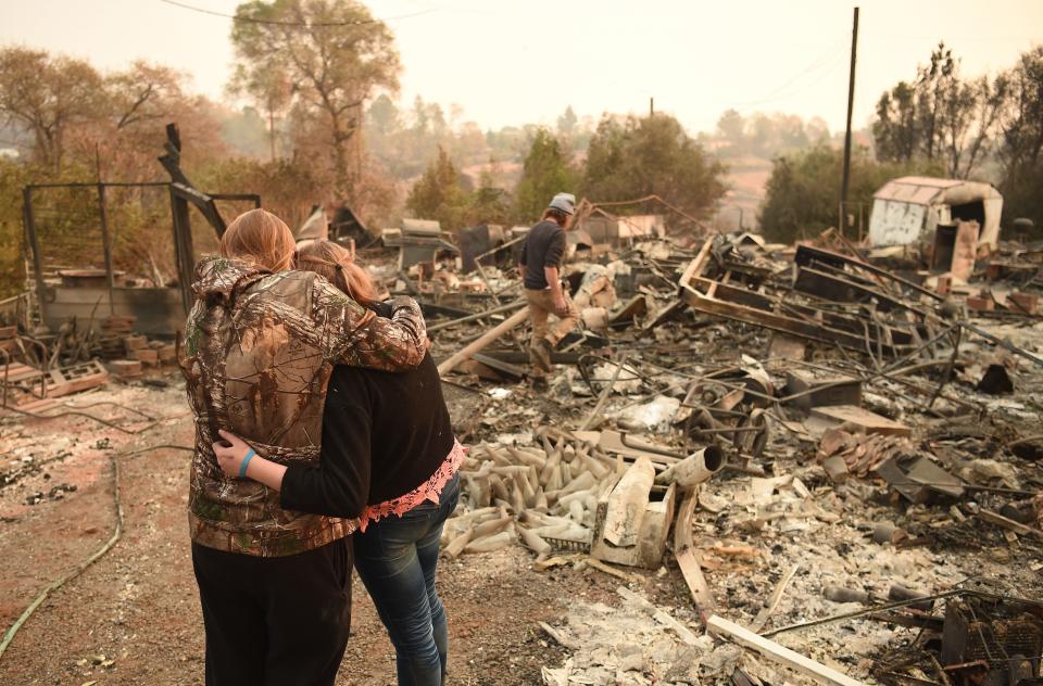 Kimberly Spainhower hugs her daughter Chloe, 13, while her husband Ryan Spainhower searches through the ashes of their burned home in Paradise, California, on Nov. 18. A new report from&nbsp;13 federal agencies has connected extreme weather events, such as wildfires, to climate change.&nbsp; (Photo: JOSH EDELSON via Getty Images)
