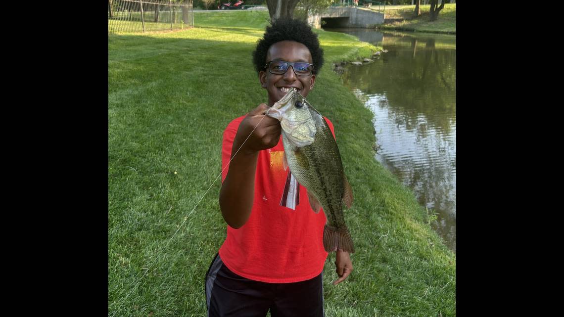 Claude Hodges Jr. smiles after catching a bass at a pond near his home in east Wichita. The 14-year-old Wichita boy was found fatally shot Monday.