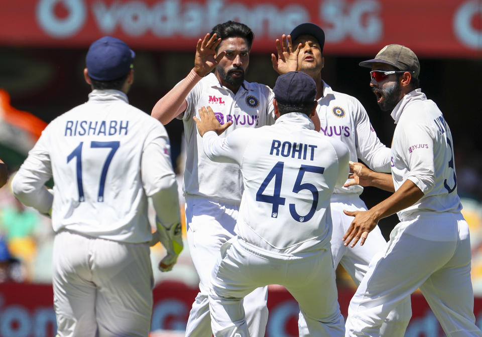 India's Mohammed Siraj, second left, celebrates with teammates after dismissing Australia's David Warner during play on the first day of the fourth cricket test between India and Australia at the Gabba, Brisbane, Australia, Friday, Jan. 15, 2021. (AP Photo/Tertius Pickard)