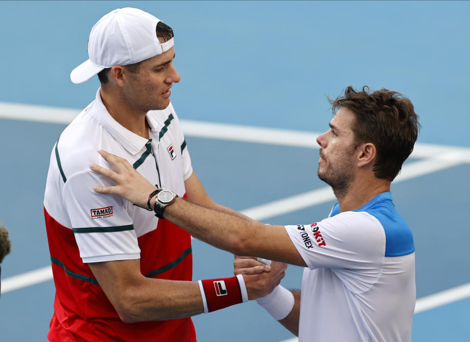 John Isner, left, of the U.S. shakes hands with Switzerland's Stan Wawrinka after retiring from their third round match at the Australian Open tennis championship in Melbourne, Australia, Saturday, Jan. 25, 2020. (AP Photo/Andy Wong)