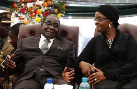 FILE PHOTO: Zimbabwe President Robert Mugabe speaks to his wife Grace during the funeral of his sister, Bridget, in the village of Zvimba