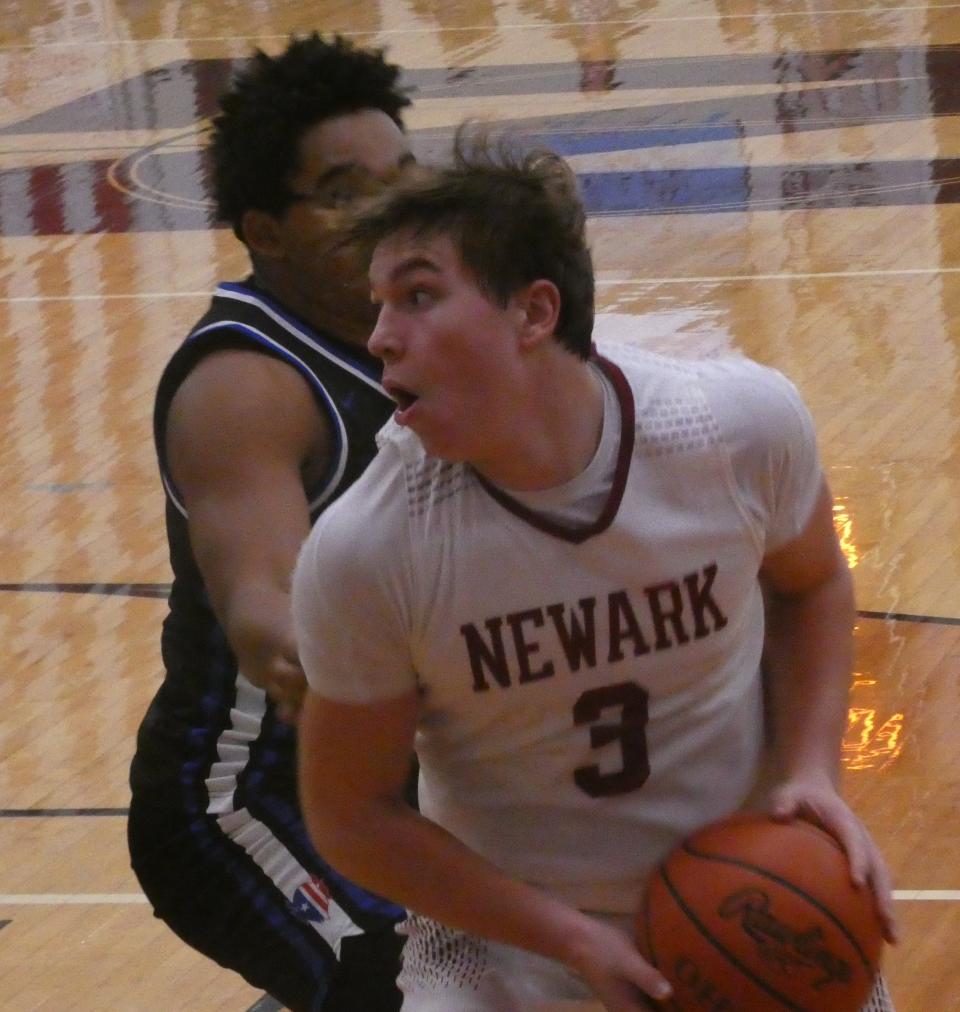 Newark junior Steele Meister turns in the post against Zanesville senior Xavier Riley at Jimmy Allen Gymnasium on Saturday, Dec. 3, 2022. The host Wildcats beat the Blue Devils 64-29, their 11th consecutive victory in the rivalry.