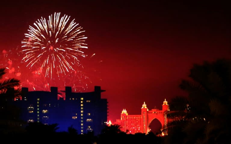 Fireworks burst over the Atlantis Hotel (R) at the man-made Palm Island in Dubai, on January 1, 2016