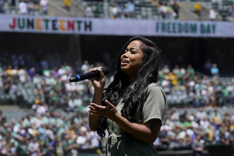 Nique performs "Lift Every Voice and Sing" in celebration of the upcoming Juneteenth holiday before a baseball game between the Oakland Athletics and the Philadelphia Phillies in Oakland, Calif., Sunday, June 18, 2023. (AP Photo/Jeff Chiu)
