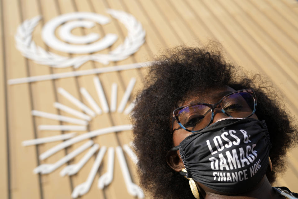 A woman wears a mask that says "loss & damage finance now" at the COP27 U.N. Climate Summit, Wednesday, Nov. 16, 2022, in Sharm el-Sheikh, Egypt. (AP Photo/Peter Dejong)