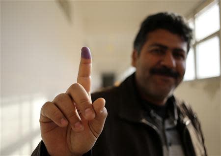 A man shows his ink-stained finger after casting his ballot during a vote to elect a constitution-drafting panel in Benghazi February 20, 2014. REUTERS/Esam Omran Al-Fetori