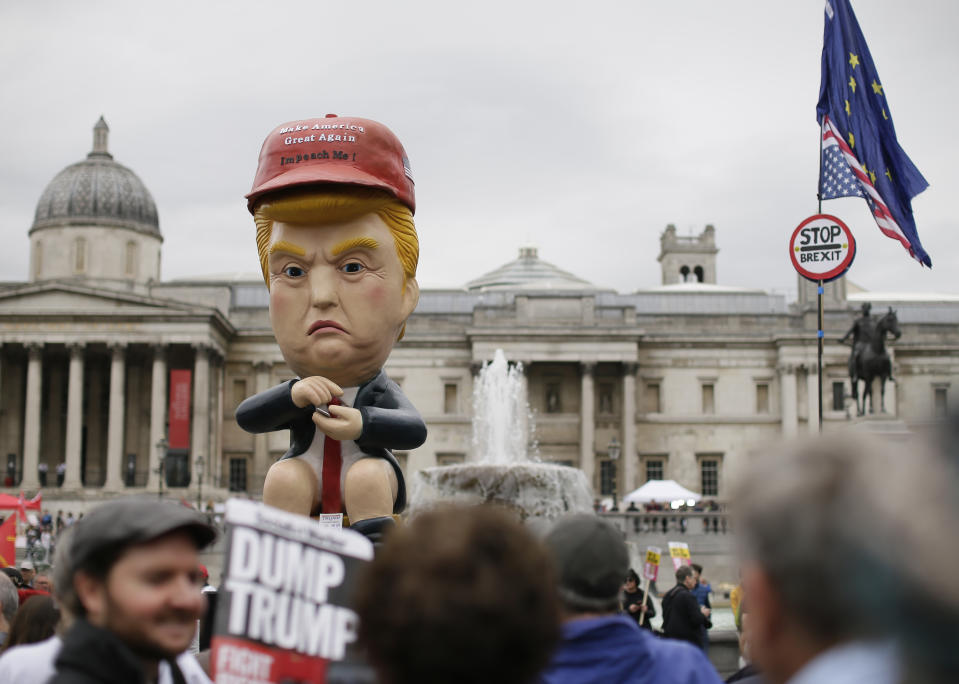 Large puppet portraying Donald Trump is carried as people gather in Trafalgar Square, central London, to demonstrate against the state visit of President Donald Trump, Tuesday, June 4, 2019. Trump will turn from pageantry to policy Tuesday as he joins British Prime Minister Theresa May for a day of talks likely to highlight fresh uncertainty in the allies' storied relationship. (AP Photo/Tim Ireland)