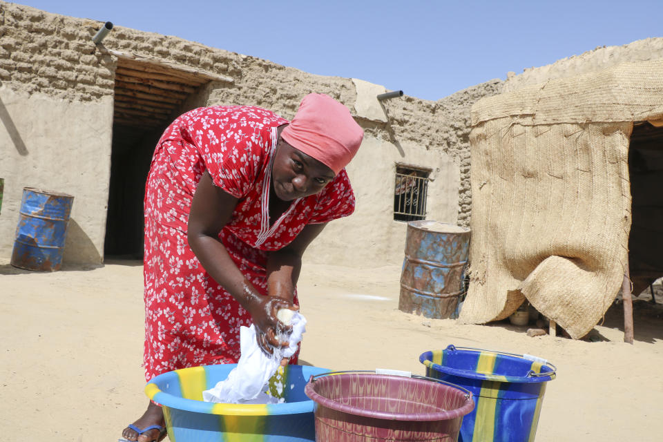 Zahra Abdou washes laundry in Timbuktu, Mali, Wednesday. Sept. 29, 2021. It's been nine years since Islamic extremists in northern Mali arrested Abdou on charges of showing her hair and wearing an outfit they said was too tight. The trauma still torments her, she says. Her anxiety has increased since France announced in July that it will reduce its 5,000 troops in Mali to about 3,000 by 2023 after years of leading the fight against jihadism in Mali's north. (AP Photo/Moulaye Sayah)