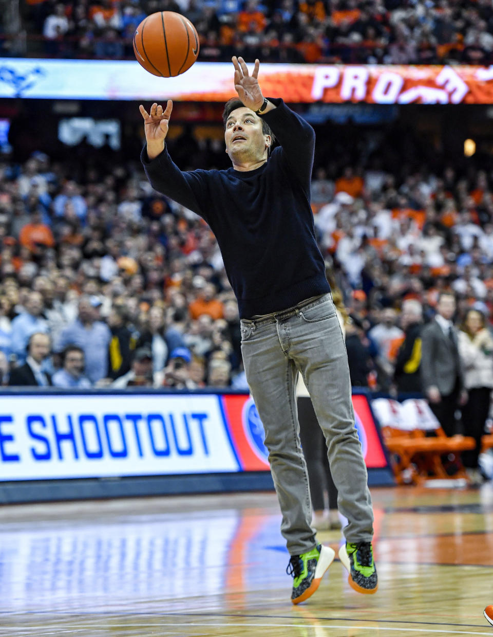 Comedian Jimmy Fallon attempts a three point shot during a timeout in the second half of an NCAA college basketball game between Syracuse and North Carolina in Syracuse, N.Y., Saturday, Feb. 29, 2020. North Carolina defeated Syracuse 92-79. (AP Photo/Adrian Kraus)