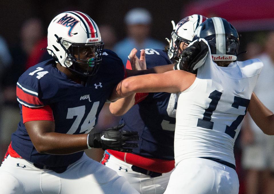 Madison-Ridgeland Academy's Jimothy Lewis, left, blocks Jackson Academy's defense during their game at Madison-Ridgeland Academy in Madison, Miss., Friday, Sept. 17, 2021.