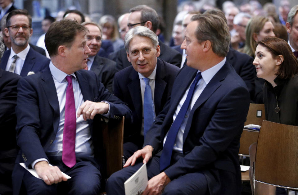 British Chancellor of the Exchequer Philip Hammond , centre, talks with former Deputy Prime Minister Nick Clegg and former Prime Minister David Cameron, in Westminster Abbey during a service of thanksgiving for the life and work of former Cabinet Secretary Jeremy Heywood, in London, Thursday June 20, 2019. (Henry Nicholls/Pool Photo via AP)