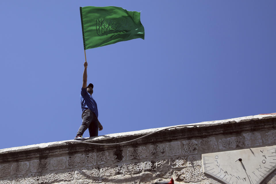 A worshipper waves the Hamas flag during a protest against the likely evictions of Palestinian families from the homes, after the last Friday prayers of the Muslim holy month of Ramadan at the Dome of the Rock Mosque in the Al Aqsa Mosque compound in the Old City of Jerusalem, Jerusalem, Friday, May 7, 2021. (AP Photo/Mahmoud Illean)