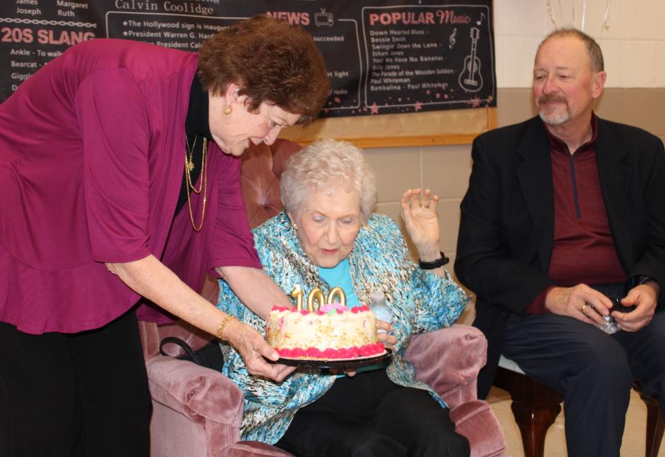 With her daughter Nancy and son Tim by her side, Arlene Layne Stanton blows candles out during her 100th birthday celebration at Bermuda Hundred United Methodist Church in Chester on December 28, 2023.