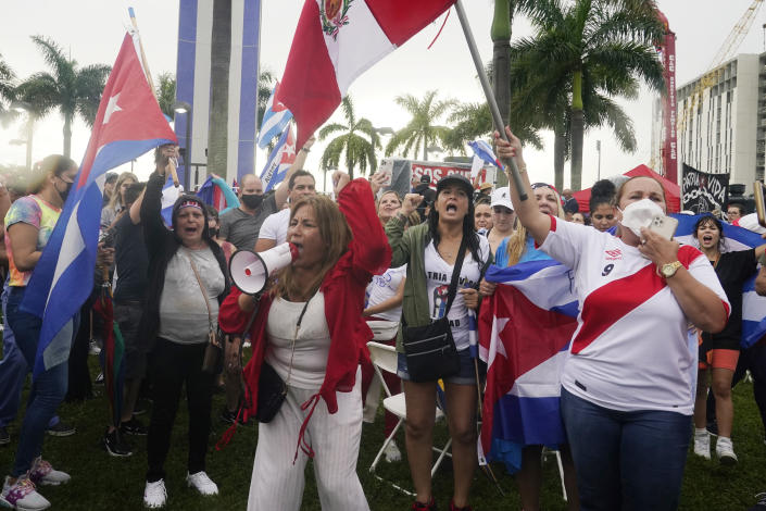 Lucy Brigman, with megaphone, leads chants against the communist regime in Cuba during a rally, Tuesday, July 13, 2021, in Miami. Demonstrators are protesting in solidarity with the thousands of Cubans who waged a rare weekend of protests around their island nation against the communist regime. (AP Photo/Marta Lavandier)