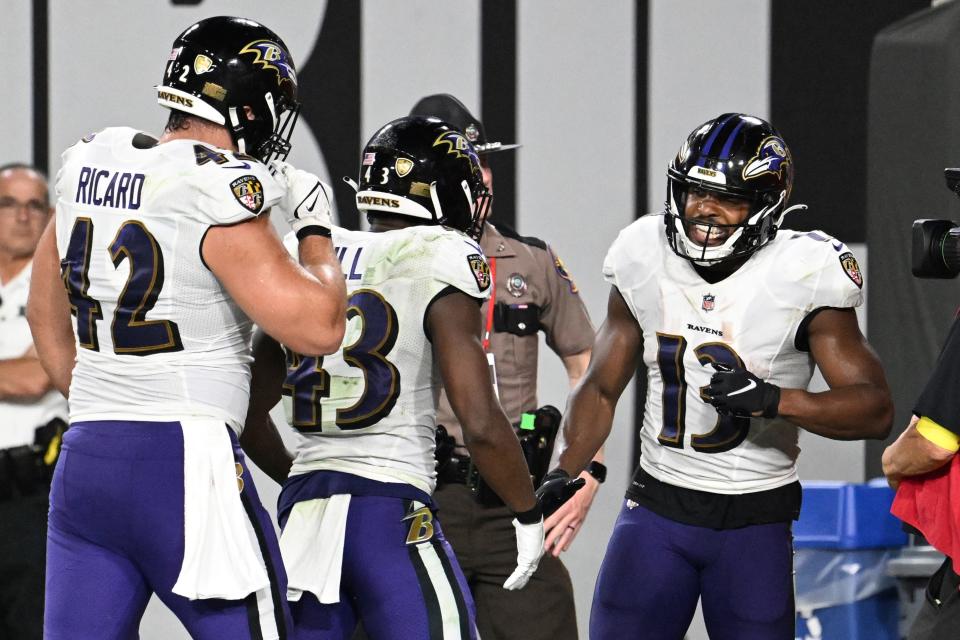 Baltimore Ravens wide receiver Devin Duvernay (13) is congratulated by Justice Hill (43) and Patrick Ricard (42) after scoring a touchdown against the Tampa Bay Buccaneers.