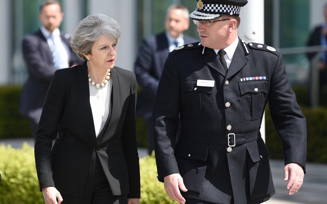 Theresa May walks with the chief constable of Greater Manchester Police, Ian Hopkins - AFP