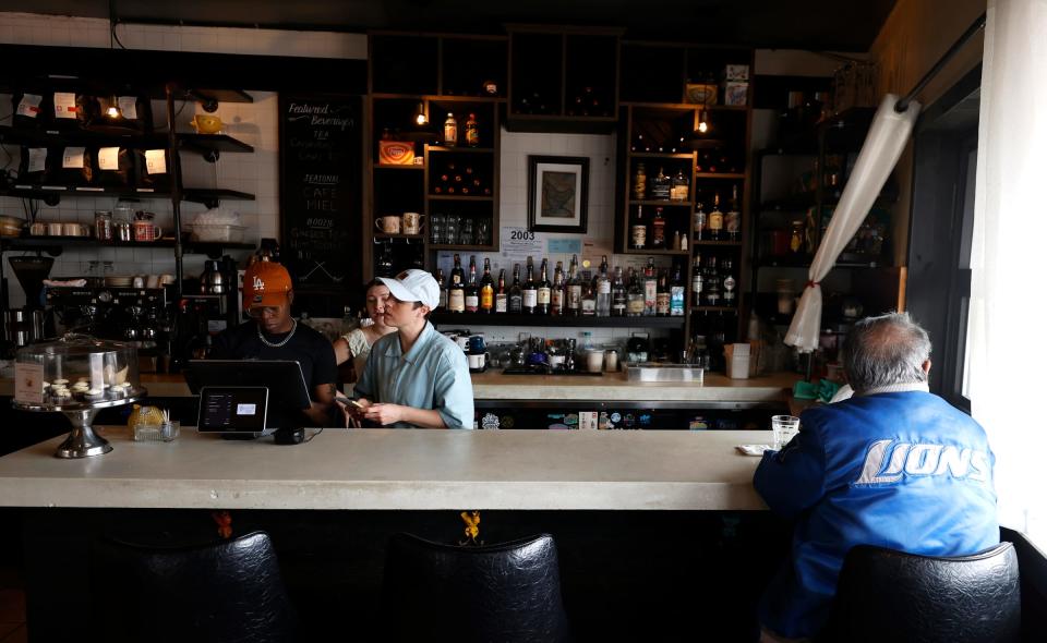 A customer has a coffee and staff work on an order inside of Brooklyn Street Local in Detrroit on Michigan near Trumbull on Thursday, March 7, 2024. The owners are hoping that the upcoming NFL draft happening in Detroit near the end of April helps bring more customers to them.