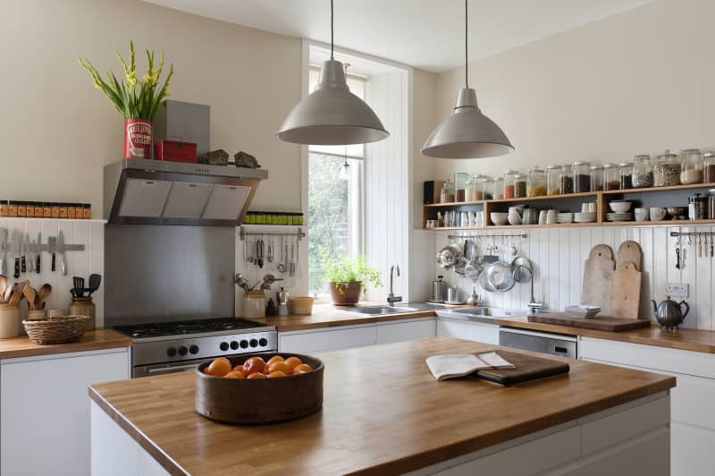 Spacious kitchen with open shelving and solid oak work surfaces. The pendant lights and units are both by Ikea.