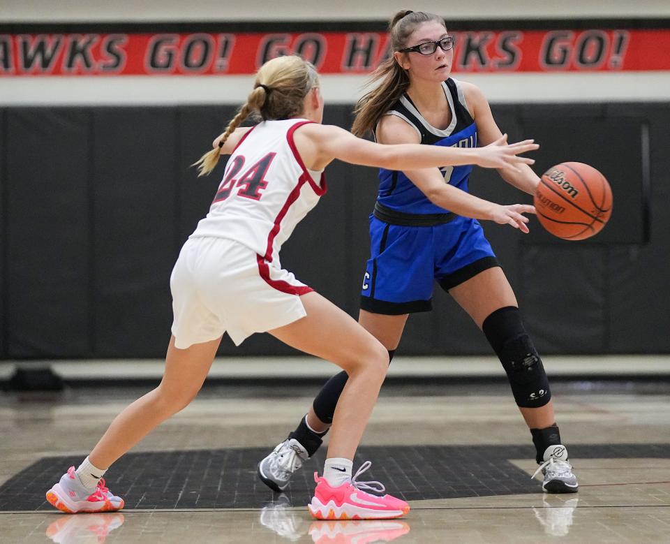 Carroll Cougars Alli Harness (2) passes the ball against Sheridan Blackhawks Brielle Garner (24) on Thursday, Nov. 9, 2023, during the game at Sheridan High School in Sheridan. The Carroll Cougars defeated the Sheridan Blackhawks, 48-44.