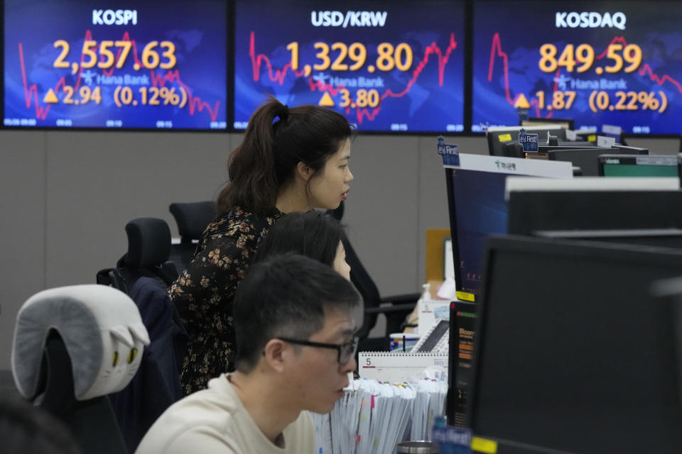 Currency traders watch monitors near the screens showing the Korea Composite Stock Price Index (KOSPI), top left, and the foreign exchange rate between U.S. dollar and South Korean won, top center, at the foreign exchange dealing room of the KEB Hana Bank headquarters in Seoul, South Korea, Friday, May 26, 2023. Asian markets were mixed Friday as a deadline loomed for Congress to reach a deal on the U.S. government debt or face a potentially calamitous default. (AP Photo/Ahn Young-joon)